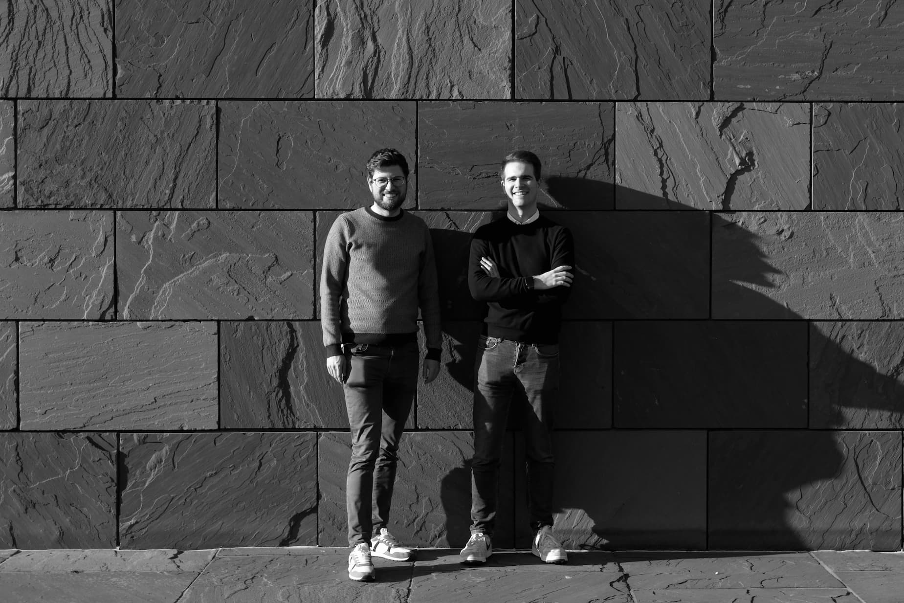 A photo of Tandem's cofounders Mathias and Maxime standing in front of a wall.