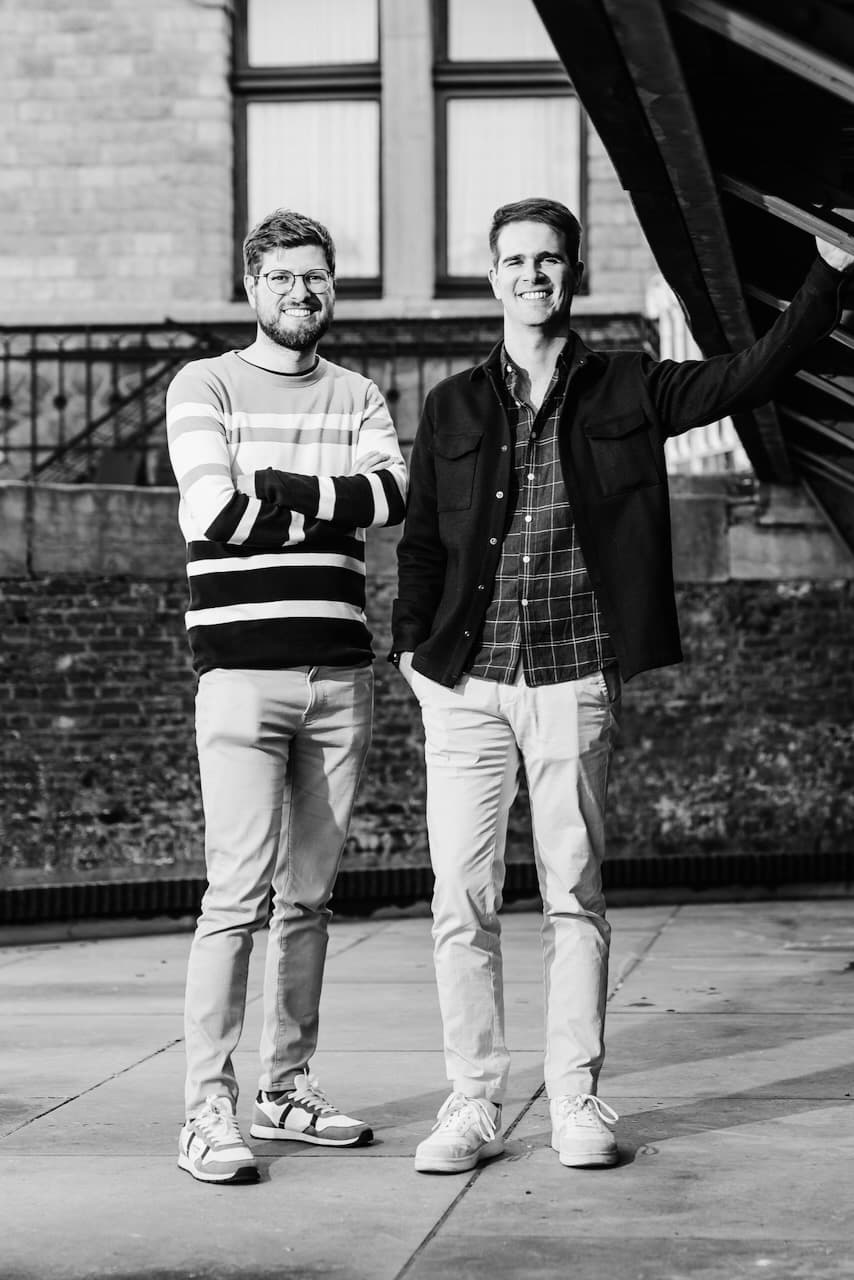 A photo of Tandem's cofounders Mathias and Maxime standing in front of a wall.